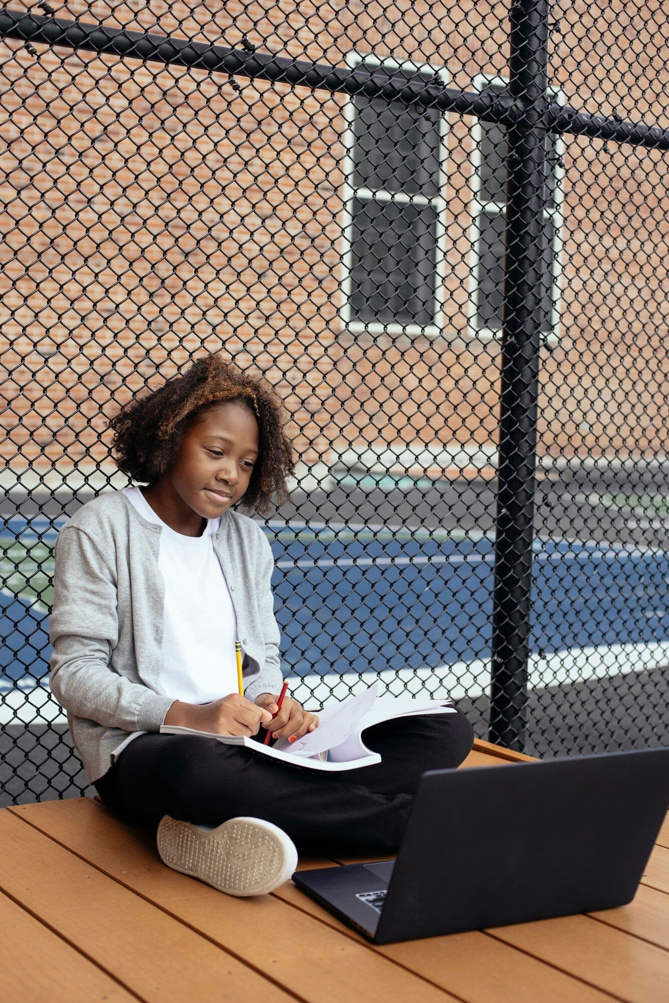 A learner studies outdoors with a laptop